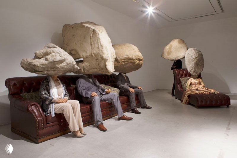 Композиция со увеличенными текстурными головами, помещёнными на диваны; сюрреалистическая инсталляция об утрате идентичности и коммуникации.