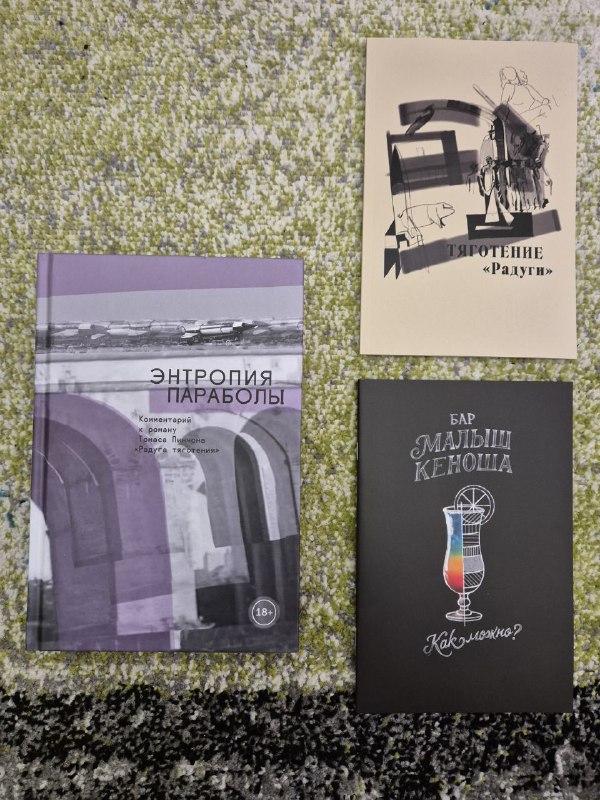 Крупный план: обложка «Энтропия параболы», буклет «Радуга» и коктейльная карта рядом на фоне ковра