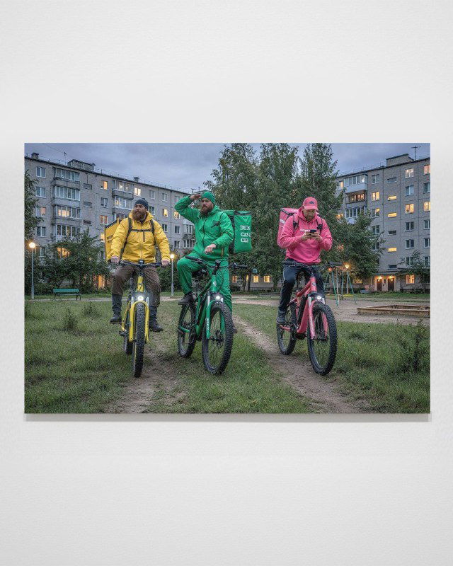 Серия Verlib: переосмысленные полотна через ИИ — курьёзная сценка с курьерами на велосипедах в цветных куртках на фоне типичной городской застройки.