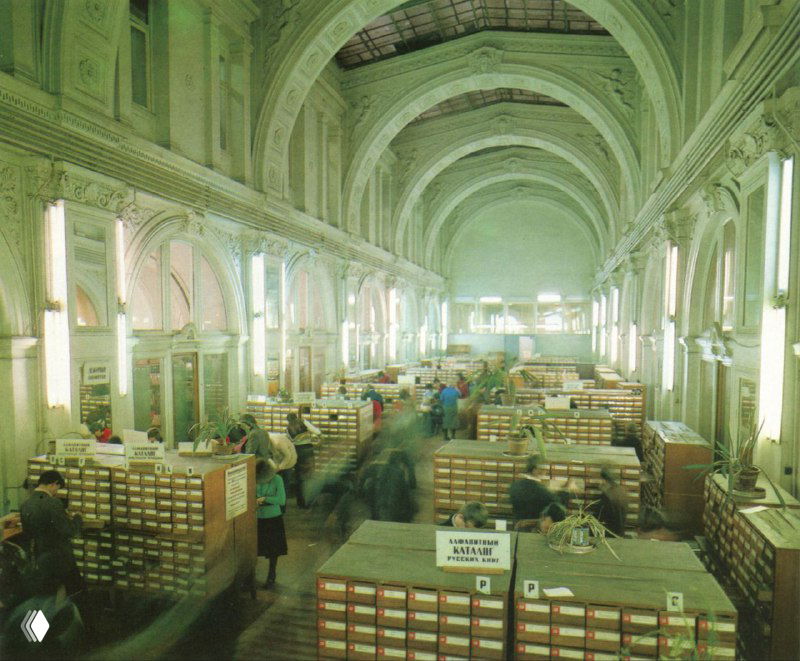 Интерьер библиотеки с рядами картотек и читателями, панорамный вид зала Государственной публичной научно‑технической библиотеки в советский период.