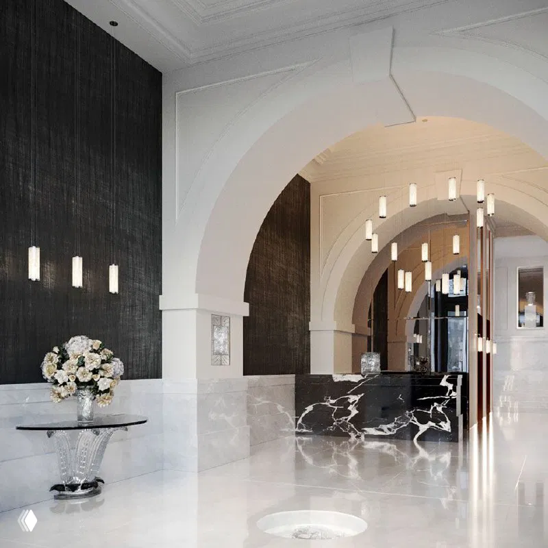 Роскошный современный вестибюль клубного дома Kuznetsky Most 12 by Lalique с мраморной отделкой, аркой и декоративными подвесными светильниками.