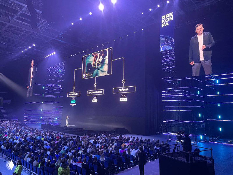 Презентация на Rekonfa: крупный экран показывает схему и иллюстрации рекламных форматов, зал слушает доклад о технологиях Яндекса.