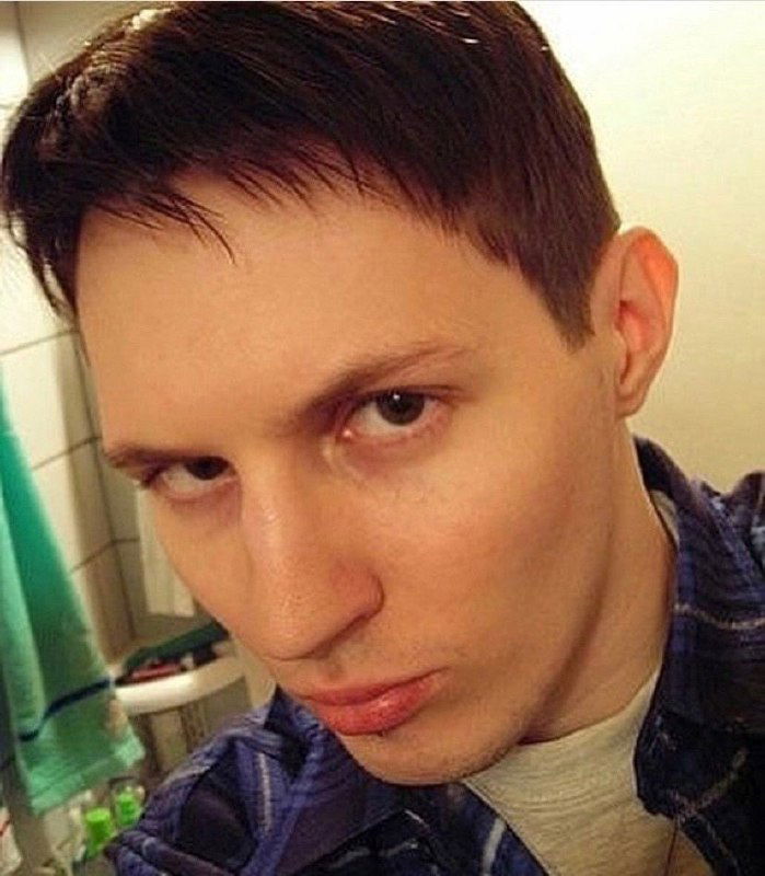 Крупный план лица в полоборота: выражение лица серьёзное, свет от лампы создаёт мягкие тени, заметен ретро-эффект снимка.