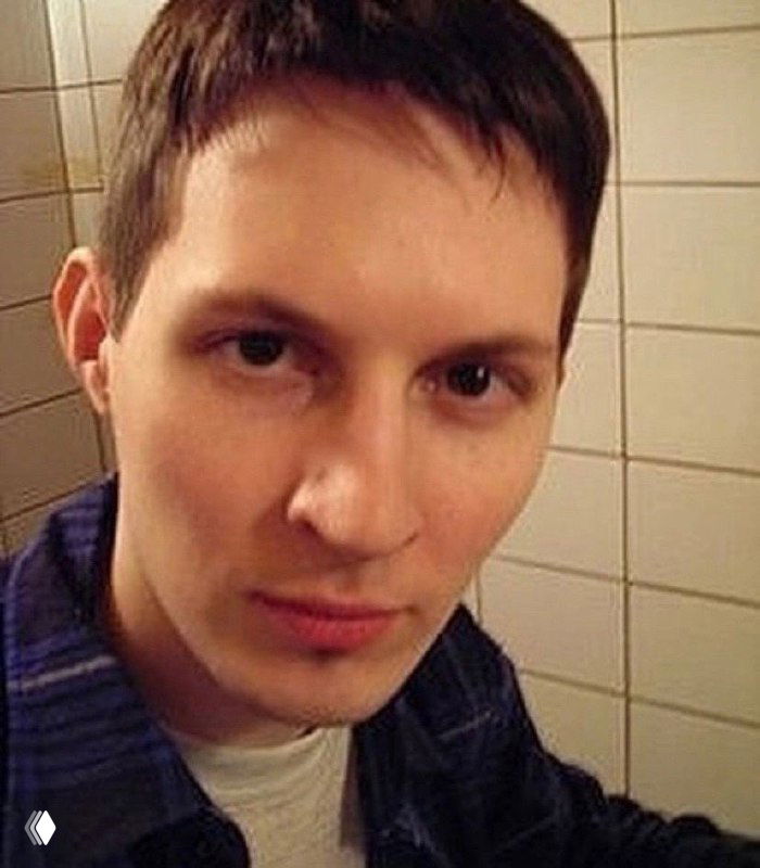 Портрет в анфас: ровный взгляд в камеру, немного зернистая текстура снимка и нейтральный фон из кафеля.