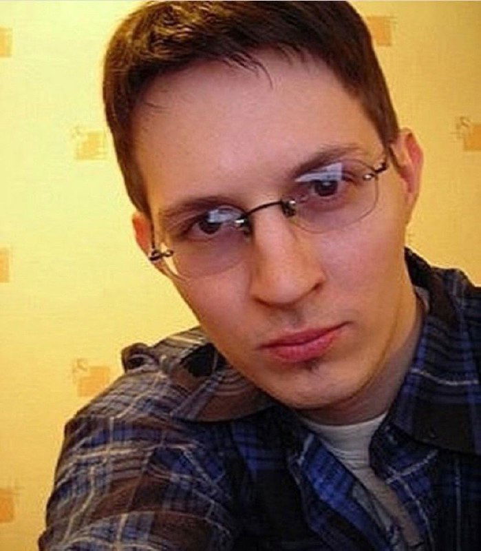 Селфи с очками: молодой человек смотрит в камеру вблизи, заметны очки и приглушённые цвета, ретро-атмосфера снимка.