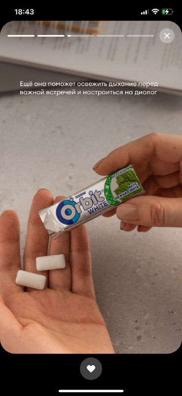 Рука держит открытый блок жвачки Orbit и две подушечки жвачки — демонстрация сценария употребления и размера порции.