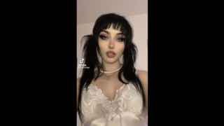 Кадр вертикального видео: молодая женщина в макияже и чёрной причёске, белом кружевном топе — типичный образ 'альта' в тикток-культуре, стилизованный и выразительный.