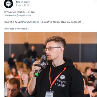 Фотография мужчины с микрофоном на конференции в свитшоте TargetHunter, аудитория и размытые участники на заднем плане.