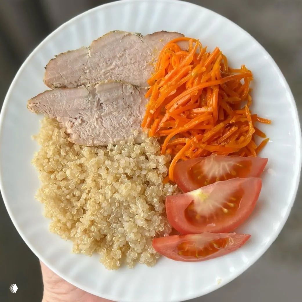 Порция киноа с запечённой бужениной, морковью по‑корейски и дольками помидора — лёгкий обед с крупой и мясом.