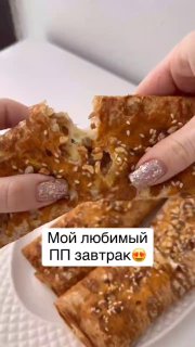 Руки держат и разламывают хрустящий лаваш с семечками, в разрезе видна сырно‑творожная начинка; фото иллюстрирует ПП‑завтрак.