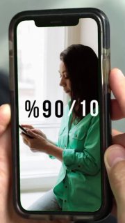 Женщина в зелёной блузке у окна смотрит в смартфон; на экране телефона крупно указано «%90/10», символ баланса формата обучения.