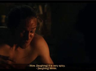 Кадр из сериала: мужчина в полумраке с английскими субтитрами «Wow. It is very spicy.» — иллюстрация жеста и контекста сцены.