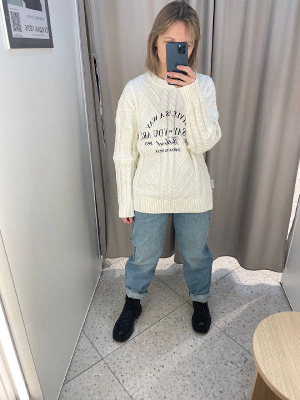 Другой ракурс примерочной примерки того же образа: свитер и джинсы, снимок в зеркало иллюстрирует свободную посадку свитера и силуэт джинсов на фигуре.