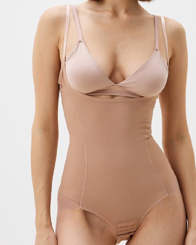 Комбинезон‑корсет бежевого цвета с бюстгальтером сверху, пример цельного белья для обтягивающих образов и поддержки формы.