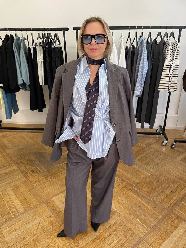 Полнофигурный снимок в шоуруме: серый жакет поверх рубашки с галстуком, образ в офисном стиле для миниатюрной фигуры.