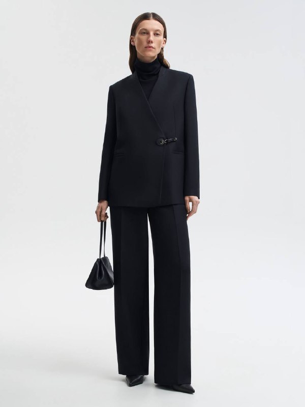 Женский образ в чёрном двубортном жакете и прямых брюках, строгий силуэт и чистые линии как признак «дороговизны».