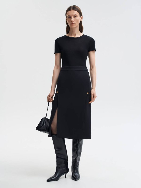 Тёмный элегантный образ: чёрная футболка и юбка со шлицем, обувь и аксессуары подчёркивают сдержанную роскошь комплекта.