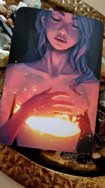 Крупный план карты с изображением женщины, держащей светящийся объект в руках; тёплые розово-оранжевые тона и мягкий контраст для визуализации чувства.