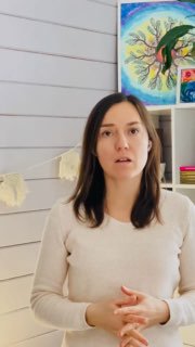 Диана, психолог в деревне, говорит в видео в светлой комнате: видно её верхнюю часть тела, белую обшитую стену, большую картину и естественные жесты рук.
