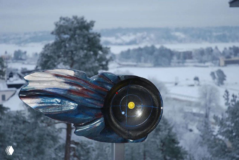 Креативная металлическая форма, похожая на комету или метеор, установленная на постаменте на фоне заснеженного пейзажа северной части Швеции.