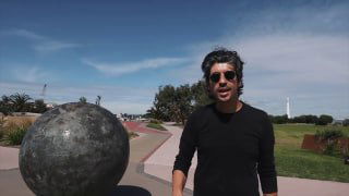 Ведущий в Мельбурне рядом со сферической моделью планеты — кадр из видео Stefan Drury о масштабах Солнечной системы