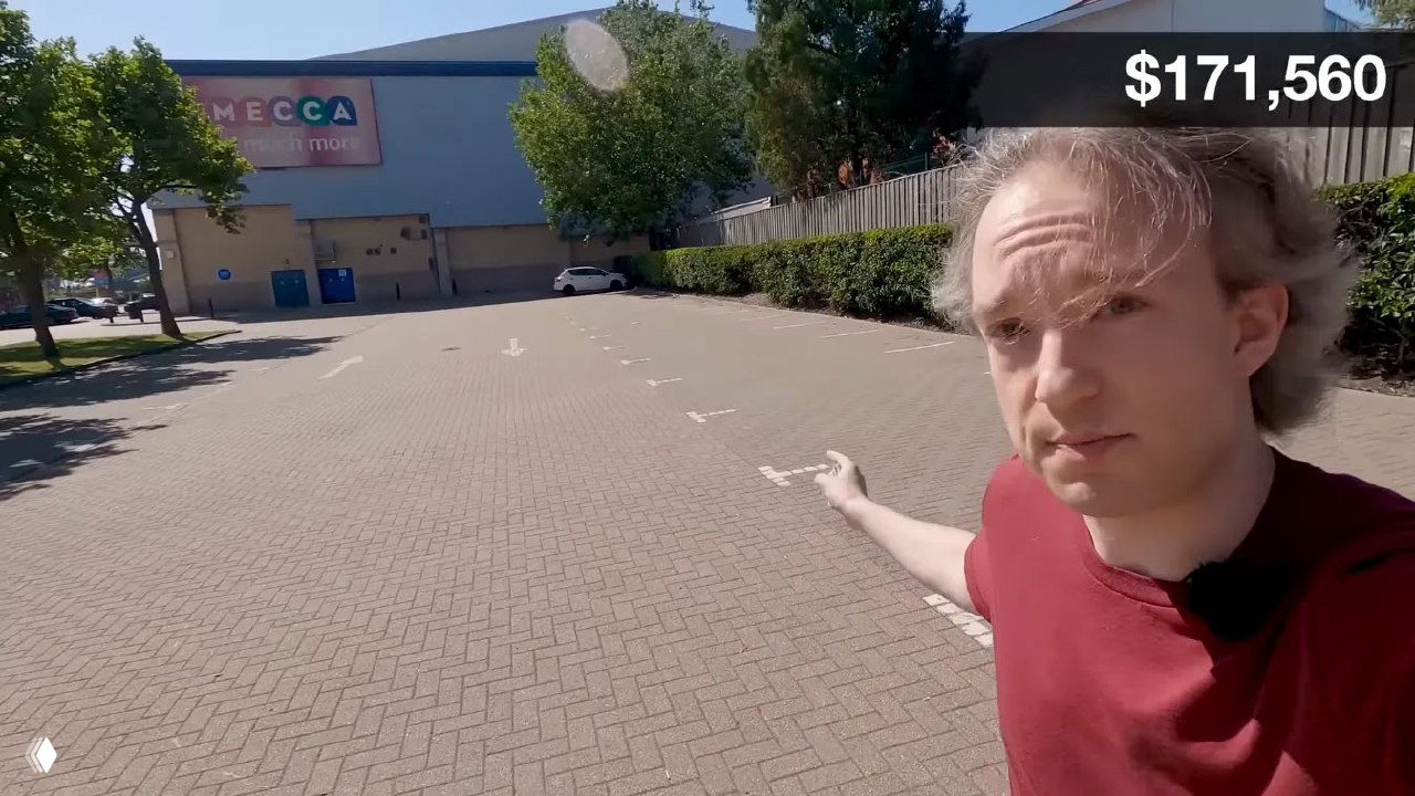 Кадр с автором видео Томом Скоттом на пустой парковке; в правом верхнем углу счётчик показывает $171,560 во время демонстрации прогресса.