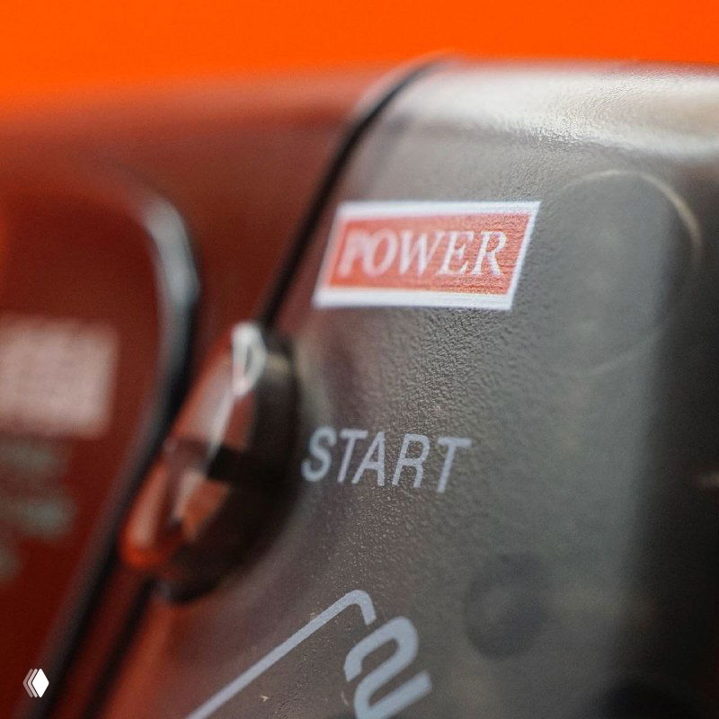 Крупный план области с надписями POWER и START на корпусе оригинальной Game Gear; черная текстура пластика и кнопки видны в деталях.