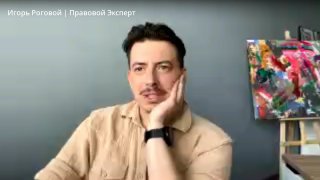 Кадр из записи эфира: ведущий сидит в студии на фоне стены и яркой картины, видна рабочая обстановка и внимание к разговору.