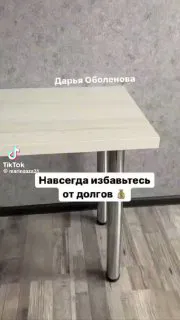 Кадр из ролика: стол и ножки стола на полу, наложен текст «Навсегда избавьтесь от долгов», демонстрация реквизита как «способа».