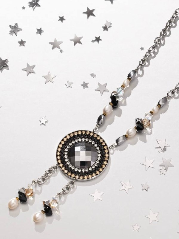Украшение: подвеска и цепочка с комбинированными кристаллами Swarovski и декоративными элементами на светлом фоне с мерцающими звёздами.