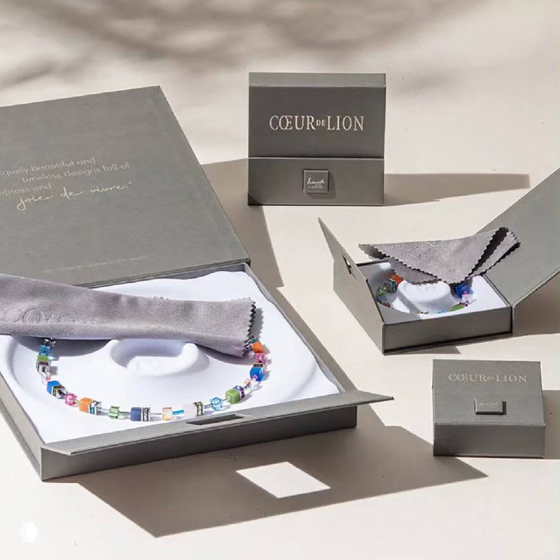 Фирменная упаковка Coeur de Lion: коробки и мешочек рядом с ожерельем из кристаллов Swarovski — показан комплект для подарка