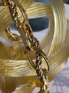 Крупный план золотой цепочки и текстуры звеньев: качественная фурнитура и витая плетёная композиция характерная для коллекций бренда.