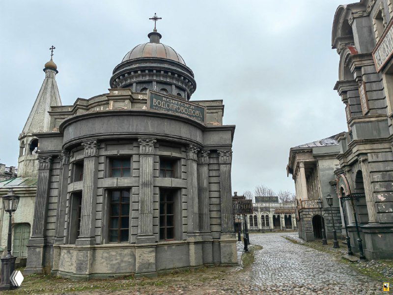 Купольное здание в центре декорации с колоннами и округлыми формами — эффект городской доминанты в петербургской сцене на Мосфильме.