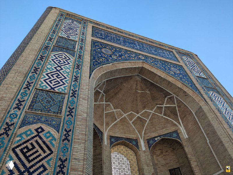 Крупный план украшенного мозаикой арочного портала мечети в Ташкенте; декоративные узоры и цветовая палитра демонстрируют национальную традицию в архитектуре.