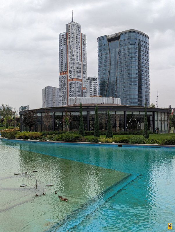 Пруд с утками и небоскрёбами Tashkent City на заднем плане; отражение зданий в воде и ухоженная набережная подчёркивают современную сторону Ташкента.