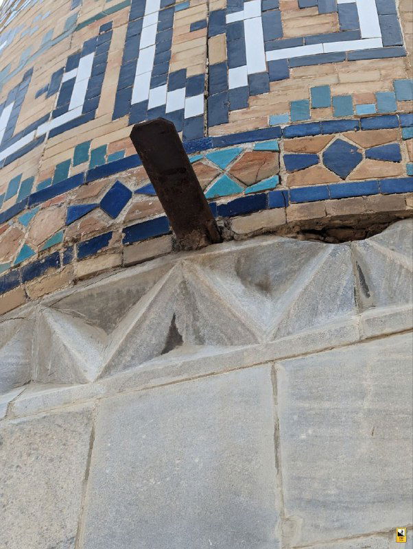 Фрагмент облицовки минарета Регистана с металлическим креплением и разноцветной глазурованной плиткой, видна продолженная кладка и мелкий декор.