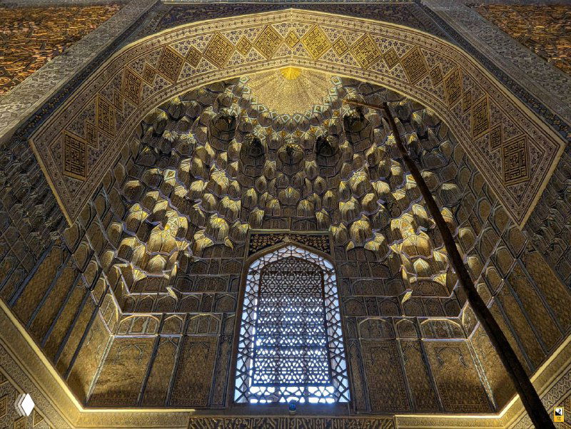 Внутреннее убранство с куполом и резными сводами: золотисто-голубая палитра, сложные узоры и глубина декоративных элементов в интерьере.