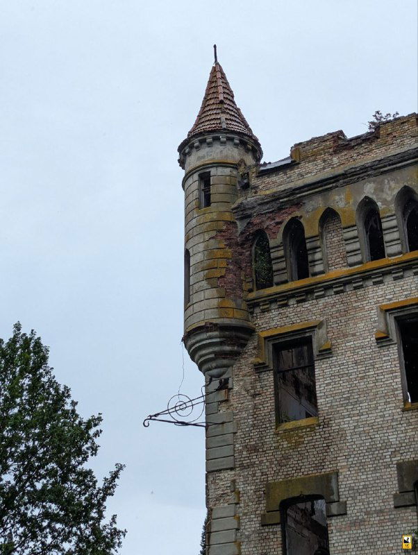 Каменная круглая башенка с коническим завершением и декоративной кирпичной кладкой — один из архитектурных элементов усадьбы Храповицкого.