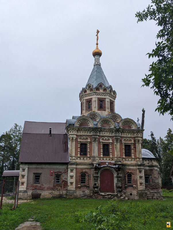 Русская православная церковь на территории усадьбы Муромцево: купол с крестом, цветная декоративная кладка и небольшой участок газона перед входом.