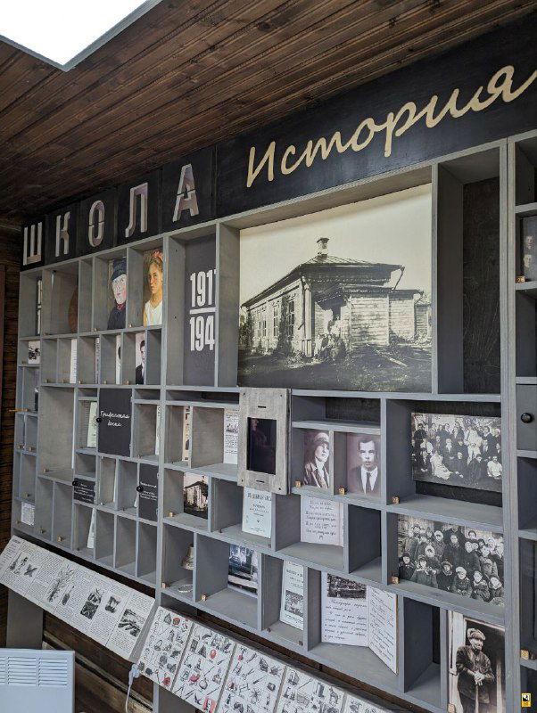 Музейная витрина с фотографиями и экспонатами истории школы в Мелихове: стенды, архивные снимки и предметы, собранные в тематической экспозиции.