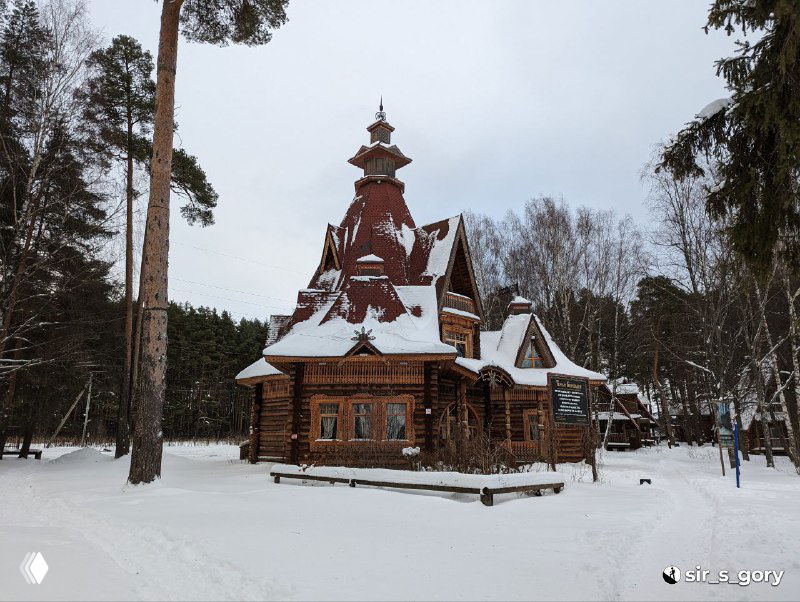 Терем Берендея со стороны: круглая башенка, купол и резные элементы фасада на фоне зимнего парка и снега вокруг здания.