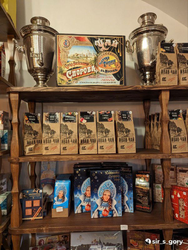 Полки с упаковками местных сладостей и самоварами в магазине: местная кондитерская продукция и традиционная подача сувениров.