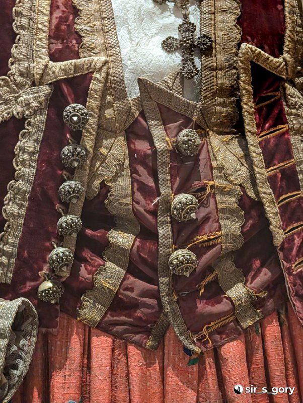 Фрагмент национального мужского костюма с пуговицами, тканевыми вставками и сложной вышивкой — экспонат, демонстрирующий региональные отличия.