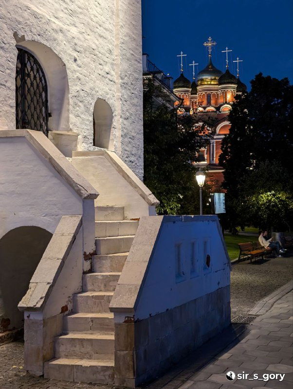 Вечерний кадр в Зарядье: архитектурные детали и купола церкви в тёплом вечернем освещении рядом с тихими аллеями парка