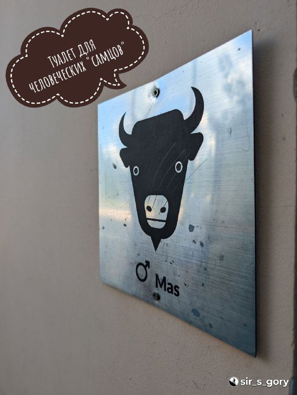 Информационная табличка с силуэтом крупного быка/зубра на металлической пластине у экспозиции питомника, графический знак и надпись.