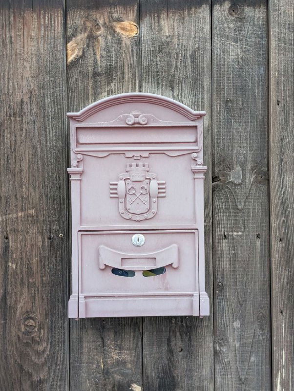 Розовая почтовая коробка на деревянной стене частного дома — маленькая деталь уличного антуража Плёса в зимний сезон.