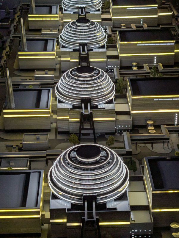 Вертикальные кольцевые макеты куполов и конструкций в экспозиции музея «Атом», многоуровневый монтаж с подсветкой и архитектурными акцентами.