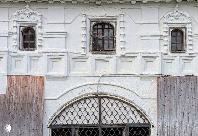 Деталь каменного фасада с резными наличниками и закрытым входом — пример северной культовой архитектуры и строительно-художественных приёмов.