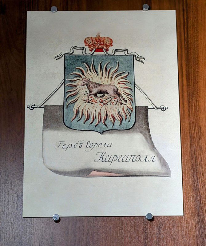 Рисунок или литография с гербом Каргополя: баран в огне на свитке, оформленный и выставленный в музее как исторический символ города.