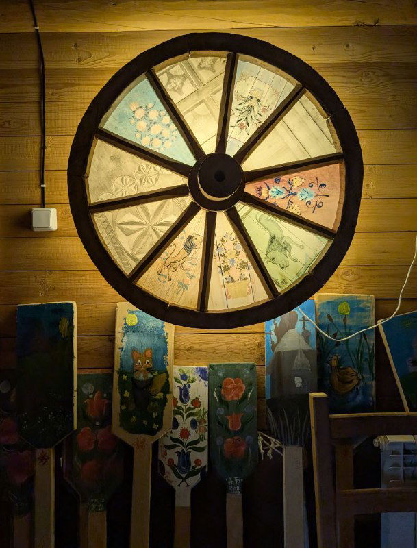 Круглое декоративное окно‑колесо с росписью и образцами народного промысла в интерьере визит‑центра нацпарка